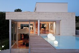 Spherical lamps in pool outside contemporary house