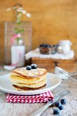 A stack of pancakes with sugar and blueberries