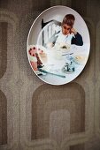Decorative wall plate with photo motif on retro-patterned wallpaper