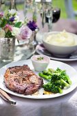 A rib-eye steak with broccoli florets served with a red wine and mustard dip with horseradish