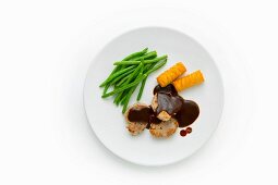 Pork medallions with carob sauce, green beans and potato croquettes