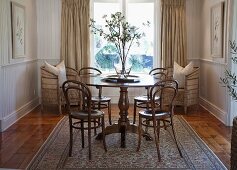 Thonet Kaffeehausstühle um rundem Tisch im Wohnzimmer mit traditionellem Flair
