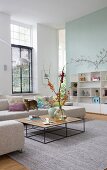 Coffee table with delicate frame and beige corner sofa in spacious, high-ceilinged interior