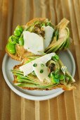 Crostini topped with artichokes, Parmesan cheese, fava beans and anchovy sauce