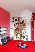 Farbintensives Schlafzimmer in rot mit Spielkarten-Motiv auf Wandschrank