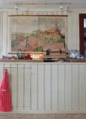 Colourful illustration above rustic, wood-clad kitchen counter