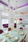Elegantly set dining table in Neo-Baroque dining area with crystal chandeliers and purple accents