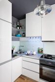 Shelves above corner sink in white fitted kitchen