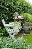 Potted plant on white wooden chair in front of vintage sewing machine used as table and barrel