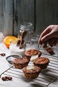 Mini orange cakes being drizzled with glaze