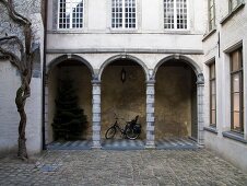 Cobbled courtyard with arcades on ground storey of traditional Flemish town house