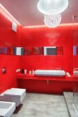 Red bathroom - walls and washstand counter with red mosaic tiles, spherical ceiling lamp made from suspended glass pendants