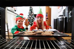 Two children baking Christmas biscuits
