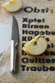 An apple quarter next to a knife