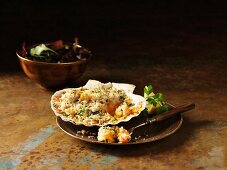 Gratinated prawns and langoustines in scallop shells garnished with lemon and coriander