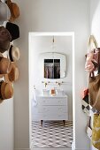 Geometrische Fliesen in Bad, Doppelwaschtisch mit minimalistischer Wandarmatur und Retro Spiegel, Hut- und Taschensammlung an der Wand
