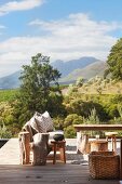 Tree stump stools on wooden terrace with view of mountain landscape