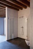 Minimalistischer, barrierefreier Duschbereich aus Glas in Loftwohnung mit Holzbalkendecke
