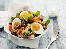 Pasta salad with hard boiled eggs, bacon, croutons and tomatoes