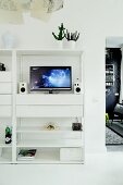 Flatscreen TV above drawers in modern, white media cabinet