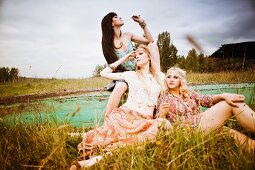 Drei junge Frauen im Hippie-Stil auf Wiese