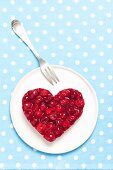 A heart-shaped cheesecake with cherry jelly