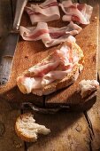 Brot mit Speck auf Schneidebrett