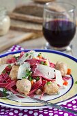 Homemade beetroot pasta with meatballs and cheese