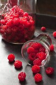 Wild raspberries spilling out of a glass