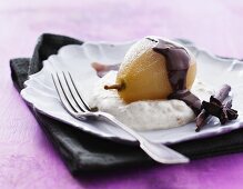 A poached pear on almond cream with chocolate sauce