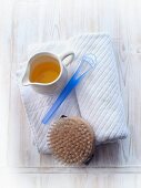 A towel, a brush and a jug of oil