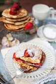 Pancakes with strawberries and icing sugar