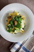 Pappadelle with courgettes, lemon, basil, caper berries and rocket (seen from above)