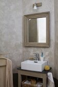 Walls marbled in umber in washing area; framed mirror above country-house washstand with modern countertop sink