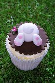 An Easter bunny cupcake on a grass surface