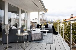 Upholstered furniture with blankets and side table on balcony