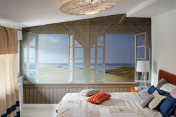 Trompe-l'œil beach mural on wall of bedroom with double bed