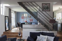 Eleganter offener Wohnbereich mit Stahltreppe und Eichenparkett in harmonisch abgestimmten graublauen Farbtönen