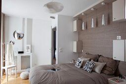 Pendant lamp above double bed against wall with wood-grain effect