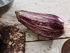 Gestreifte Aubergine auf weißen, alten Holzdielen