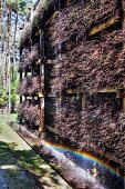 Bundles of brushwood on wooden rack against facade of house