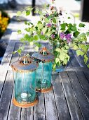 Two vintage lanterns and vase of lilac on wooden table