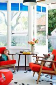 Classic retro furniture in orange in window bay with garden view