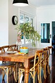 Wooden table, rustic bistro chairs and exotic-wood parquet floor in restored period apartment