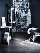 Console table, metal clothes rail and and wall covered in stylish black and white photos in open-plan dressing room