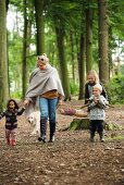 Family with dog going on autumnal picnic in woods