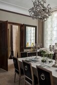 Esstafel mit mehrarmigen Silber Kerzenhaltern und antike Stühle in elegantem Esszimmer