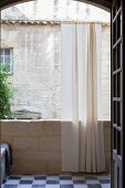 Balcony with airy curtain in arched opening