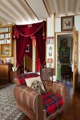 Klassisches Wohnzimmer mit antiken Möbeln und Türvorhang, Kissen mit Hundemotiv in Ledersessel