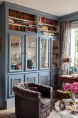 Country-house-style, floor-to-ceiling, fitted cabinets with glass doors and open-fronted shelves painted grey and blue